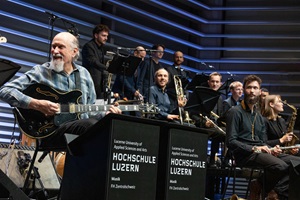 Star-Gitarrist John Scofield geniesst den Aufritt mit der HSLU Big Band auf der Bühne des Konzertsaals Salquin an der HSLU Musik. (Bild HSLU/Xenia Xezzi, November 2024)